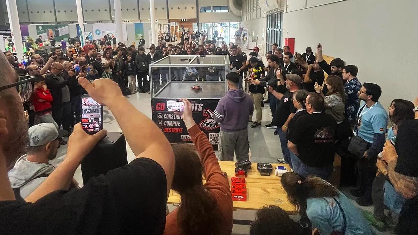 Público en pie alrededor de la arena grabando con el móvil